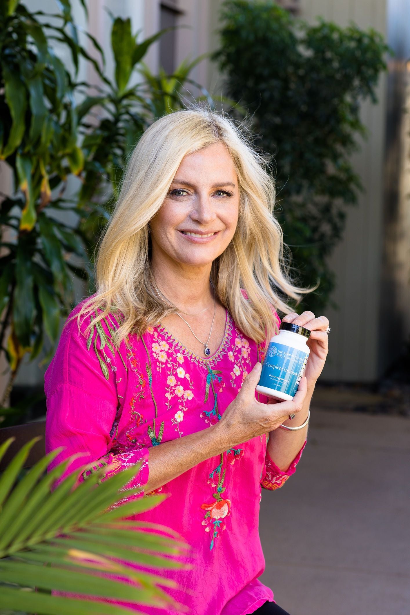 Dr. Kelly McCan holding a dietary supplement